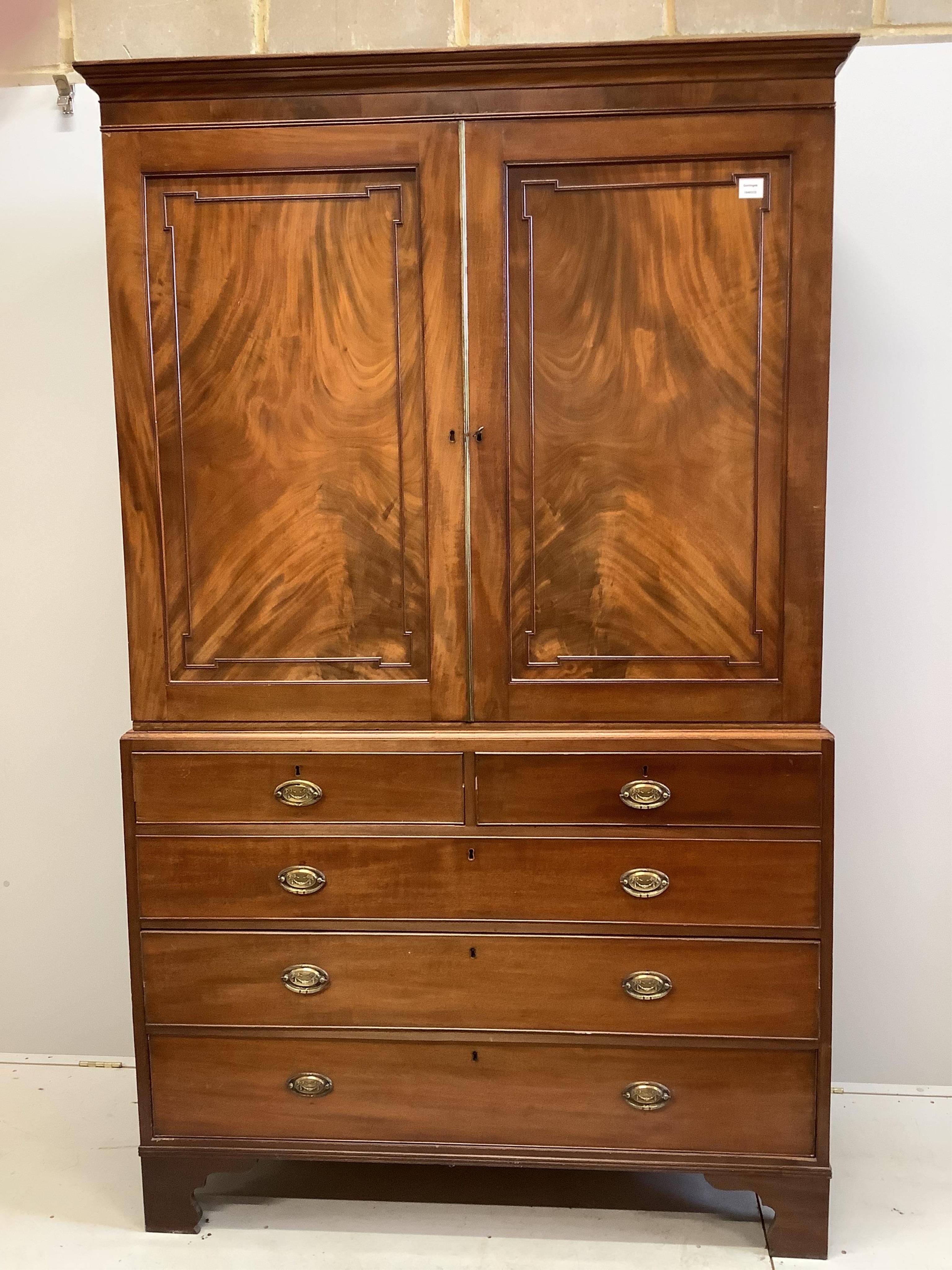 A George III mahogany linen press, converted to hanging cupboard, width 130cm, depth 58cm, height 215cm. Condition - fair, sliding trays deficient